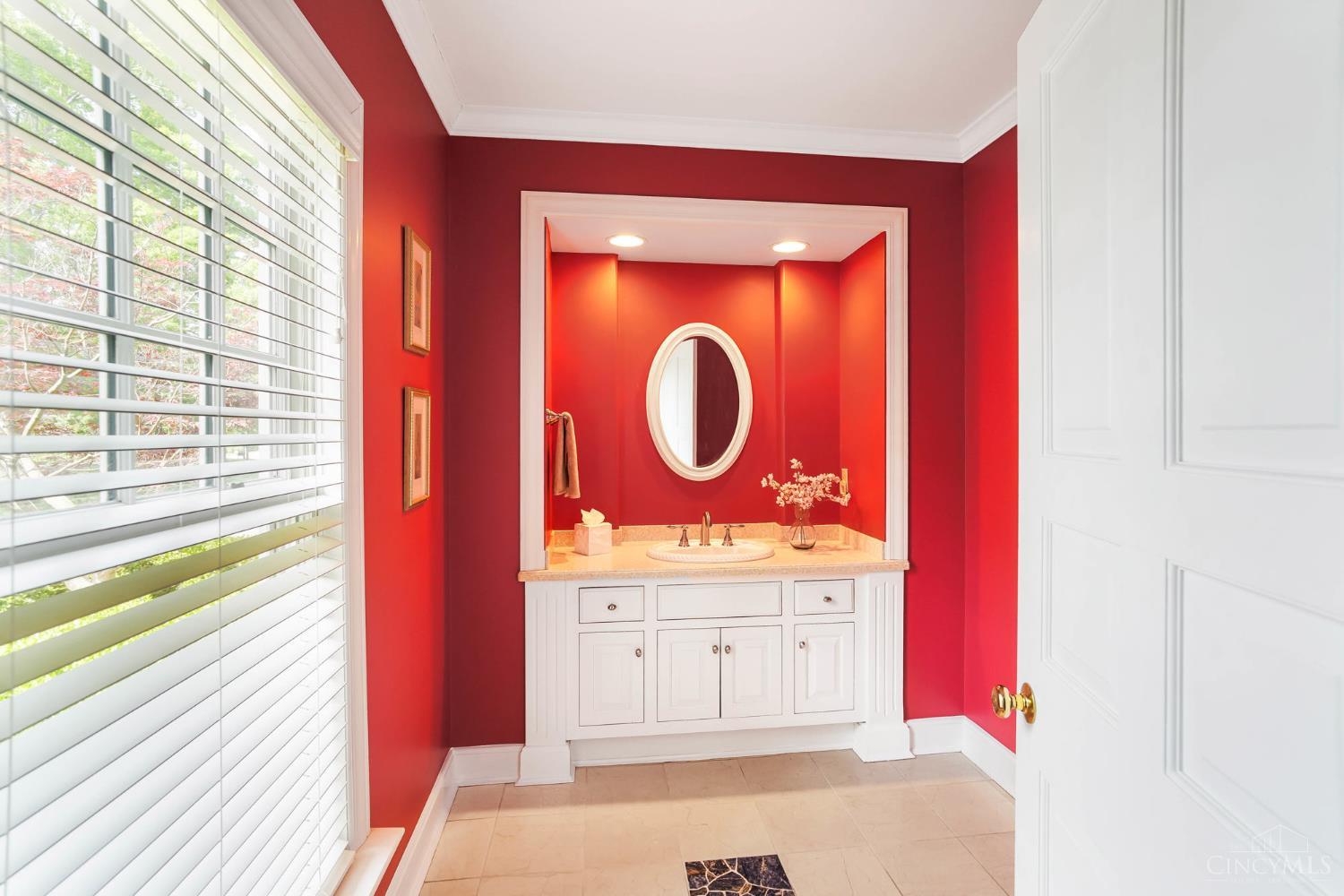 2780 Walsh Road Cincinnati, OH 45208 - Photo 23 of 68 This striking, more formal powder room just off the entry makes an immediate impression with crisp white millwork and polished fixtures, creating a timeless, elevated feel. Natural light filters through the nearby window, softening the space while highlighting its rich finishes—perfectly positioned to offer guests both style and convenience.