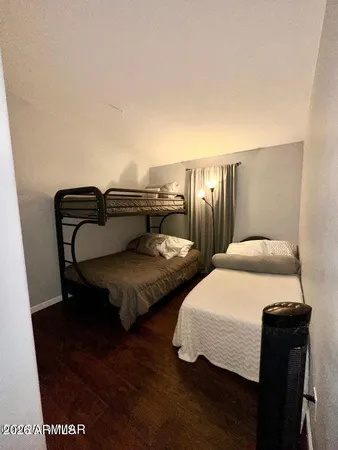 a bedroom with two beds and wooden floor