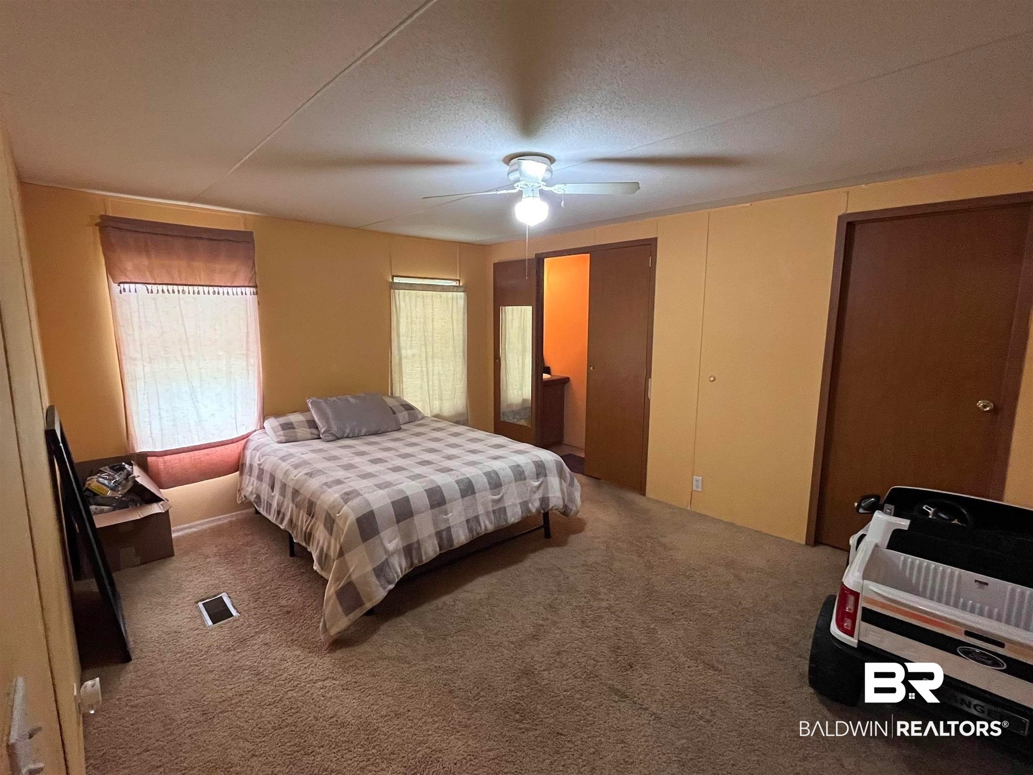 7719 Bermuda Drive Semmes, AL 36575 - Photo 6 of 10 Primary bedroom with carpet, walk-in closet, and ceiling fan. Easy access to bathroom.