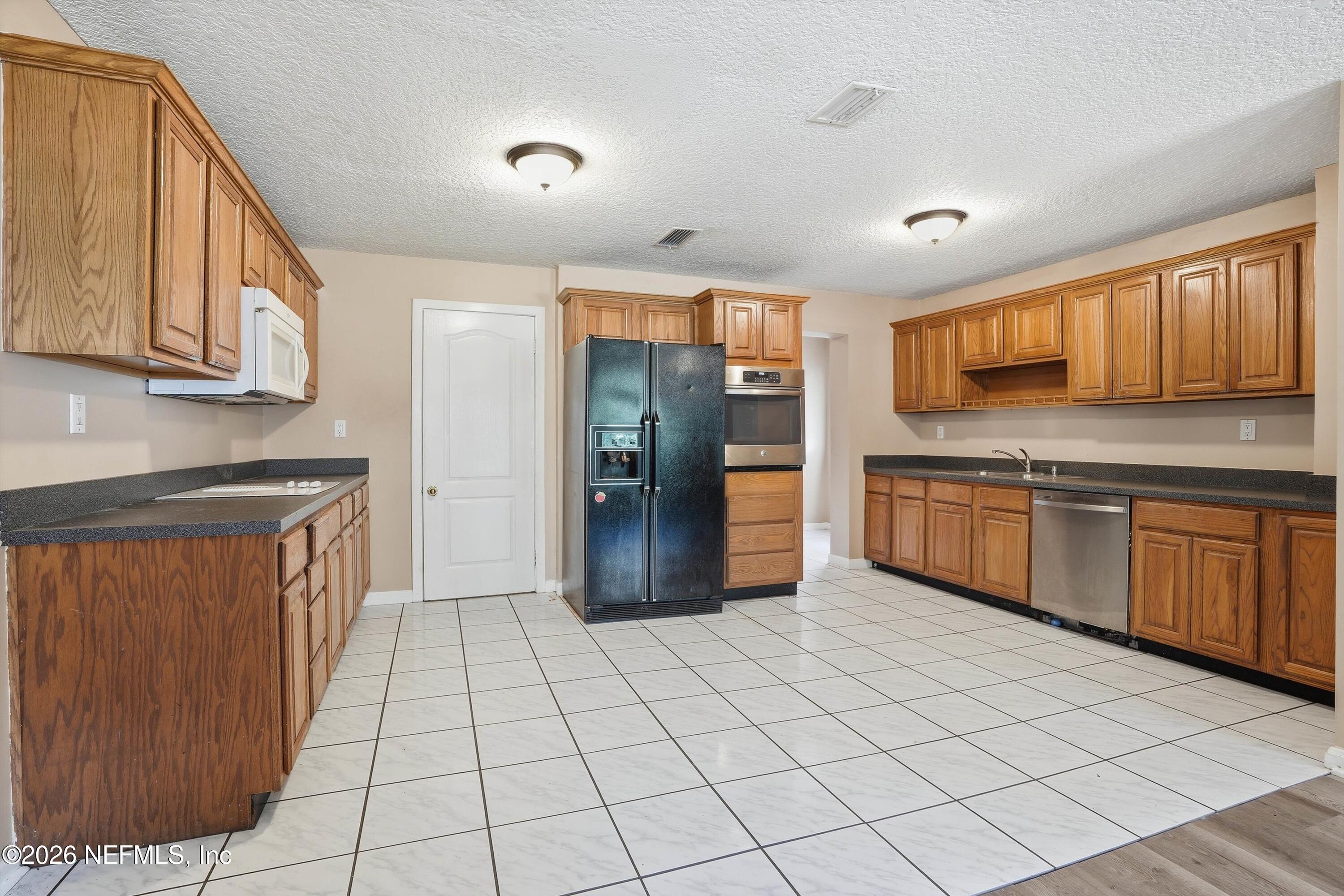 1736 Lakewood Road Jacksonville, FL 32207 - Photo 11 of 31 a kitchen with stainless steel appliances granite countertop a refrigerator and a stove top oven
