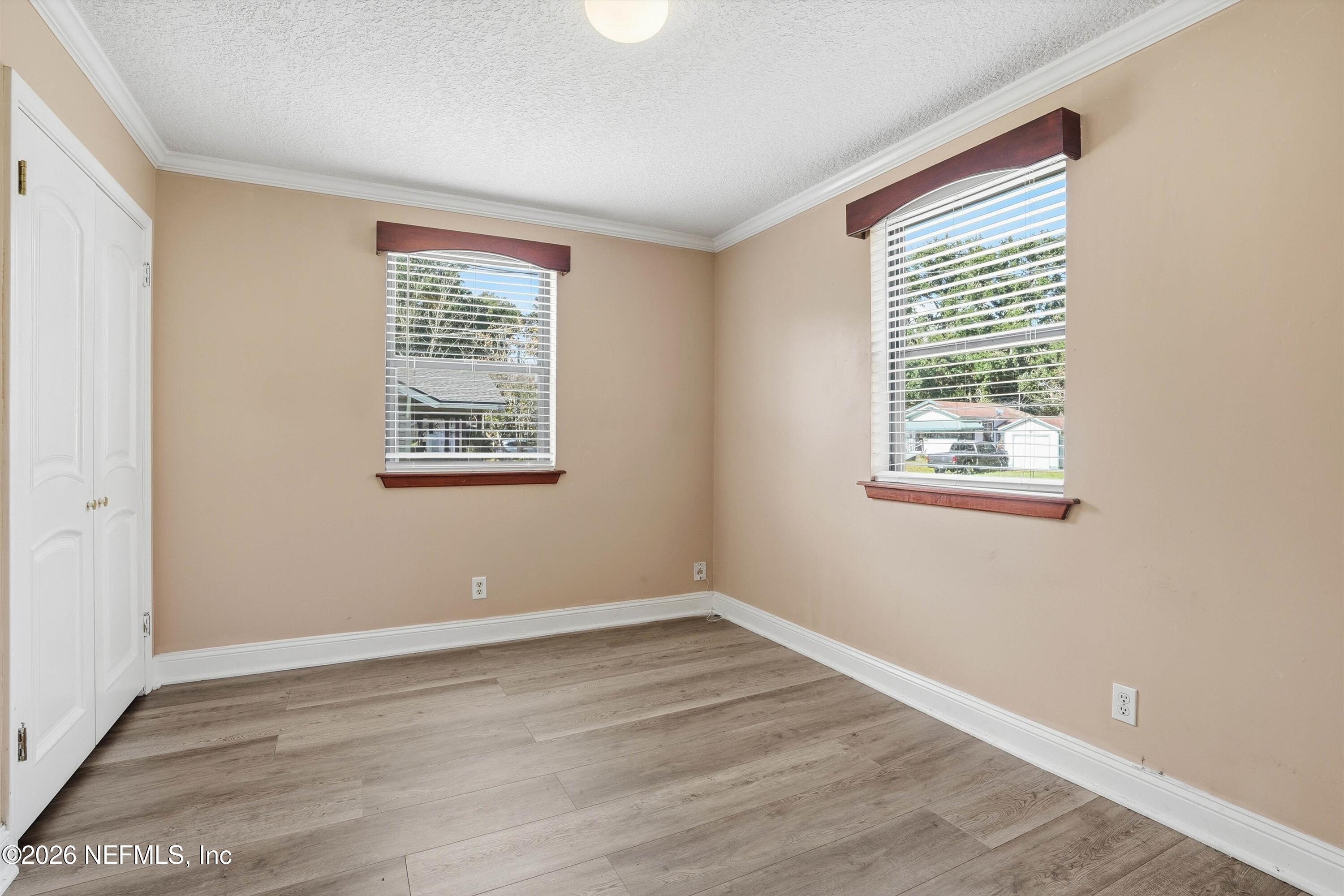 1736 Lakewood Road Jacksonville, FL 32207 - Photo 14 of 31 a view of an empty room with wooden floor and a window