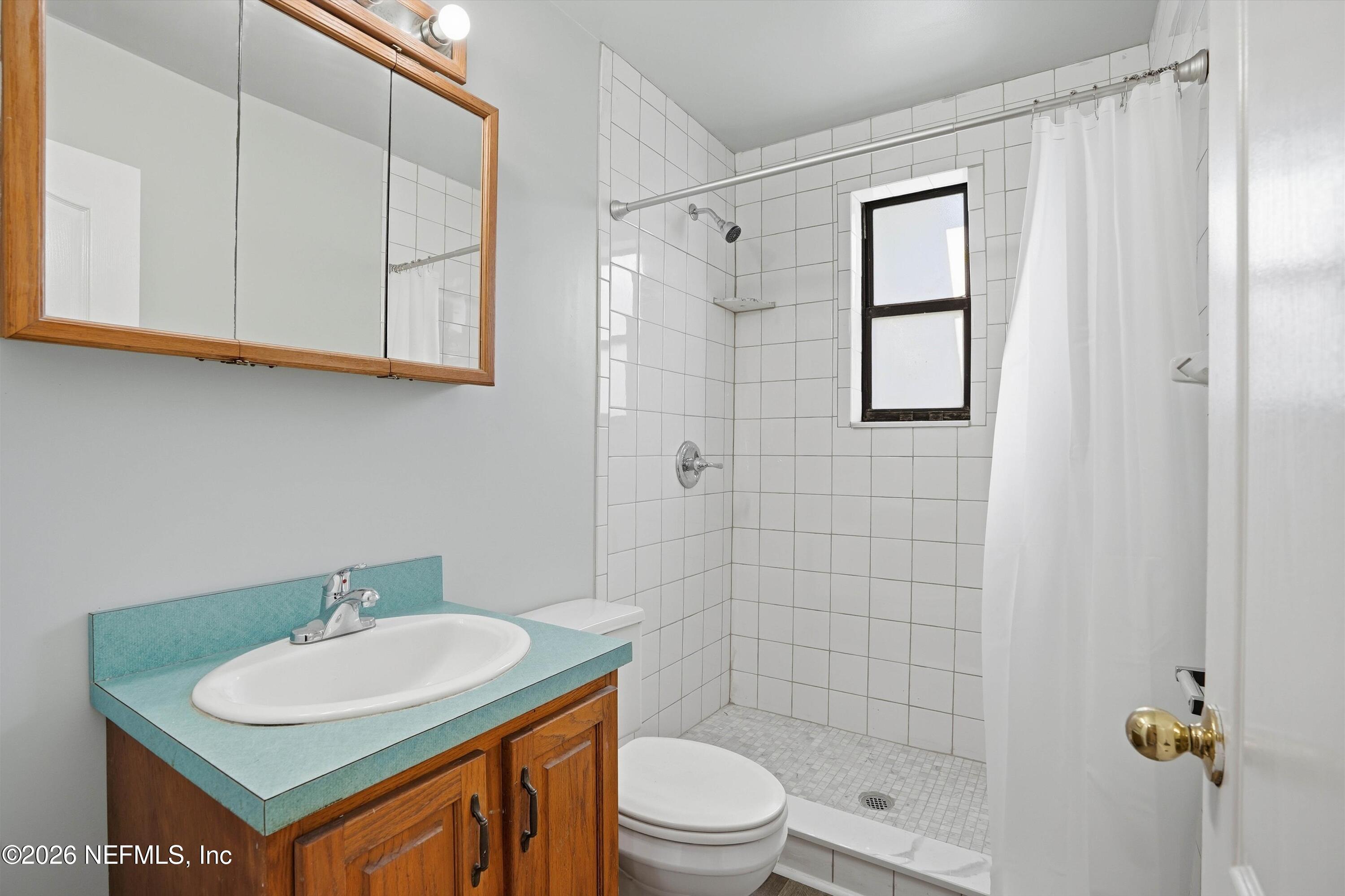 1736 Lakewood Road Jacksonville, FL 32207 - Photo 18 of 31 a bathroom with a sink toilet and shower