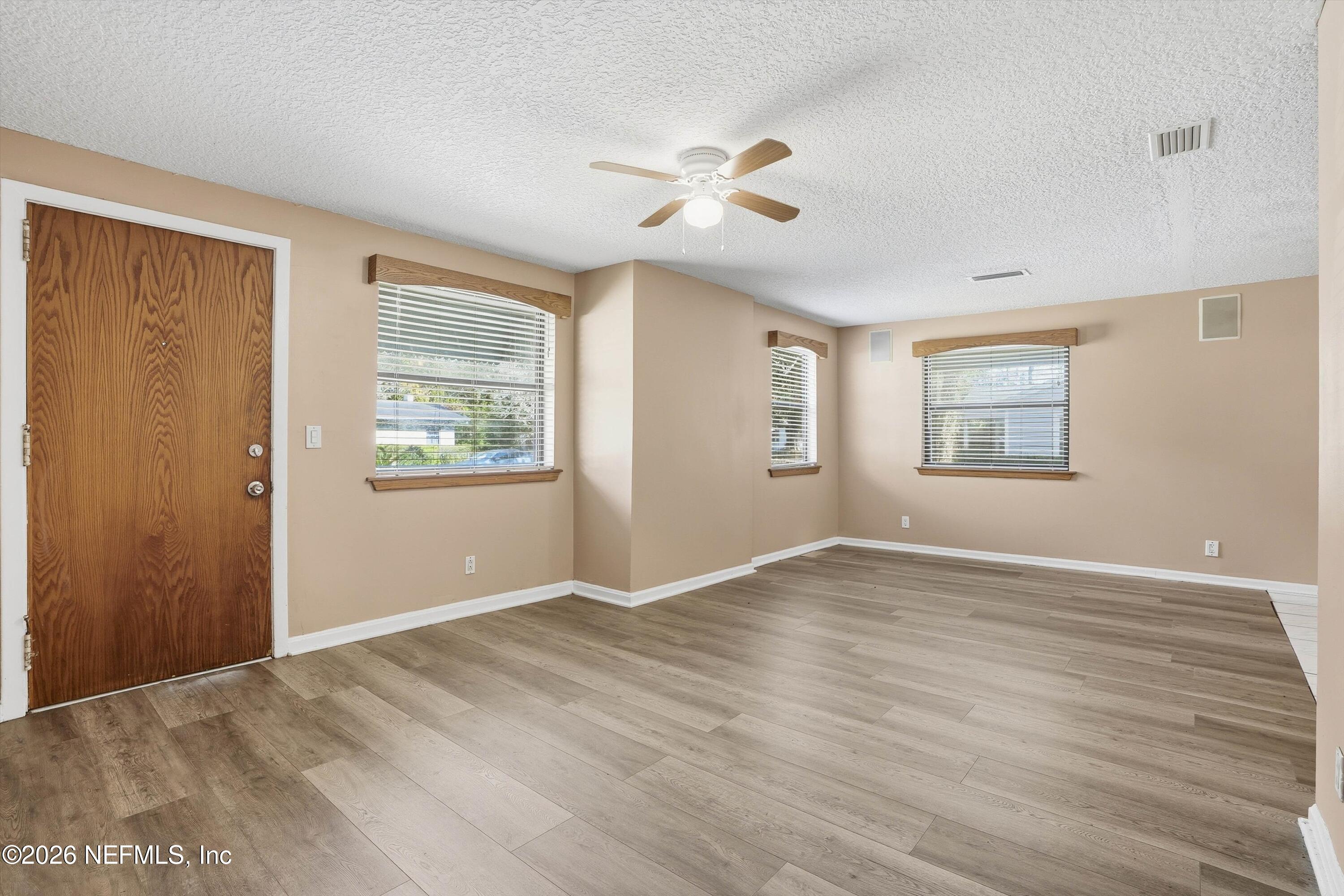 1736 Lakewood Road Jacksonville, FL 32207 - Photo 7 of 31 a view of an empty room with wooden floor and a window