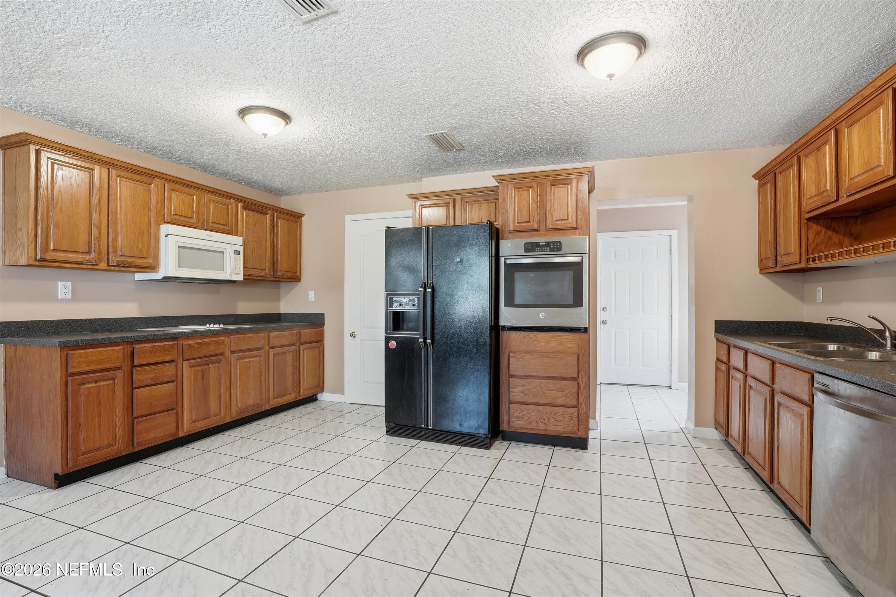 1736 Lakewood Road Jacksonville, FL 32207 - Photo 10 of 31 a kitchen with stainless steel appliances granite countertop a refrigerator and a stove top oven