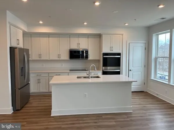 a kitchen with kitchen island a refrigerator sink and microwave