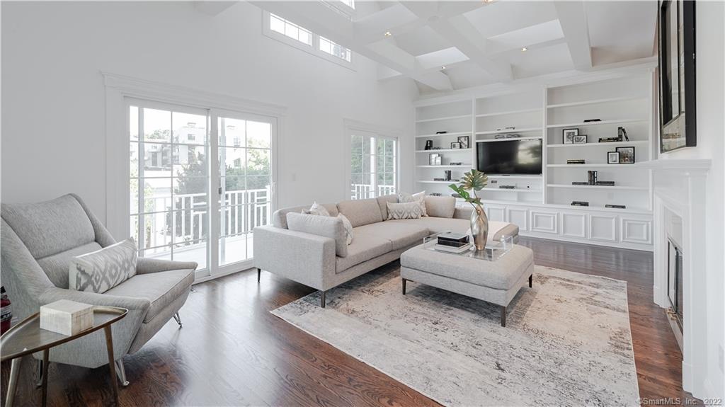 Oversized living room with gas fireplace, built in bookshelves and lighting and access to the balcony with newer sliders.