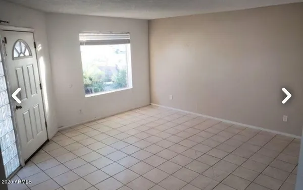 en empty room with windows and brick walls