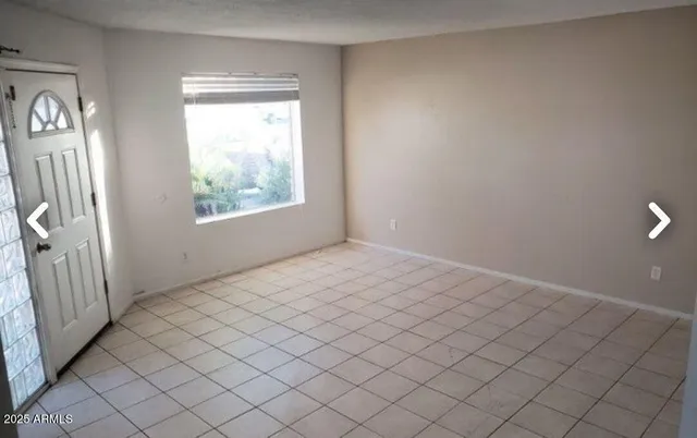 en empty room with windows and brick walls