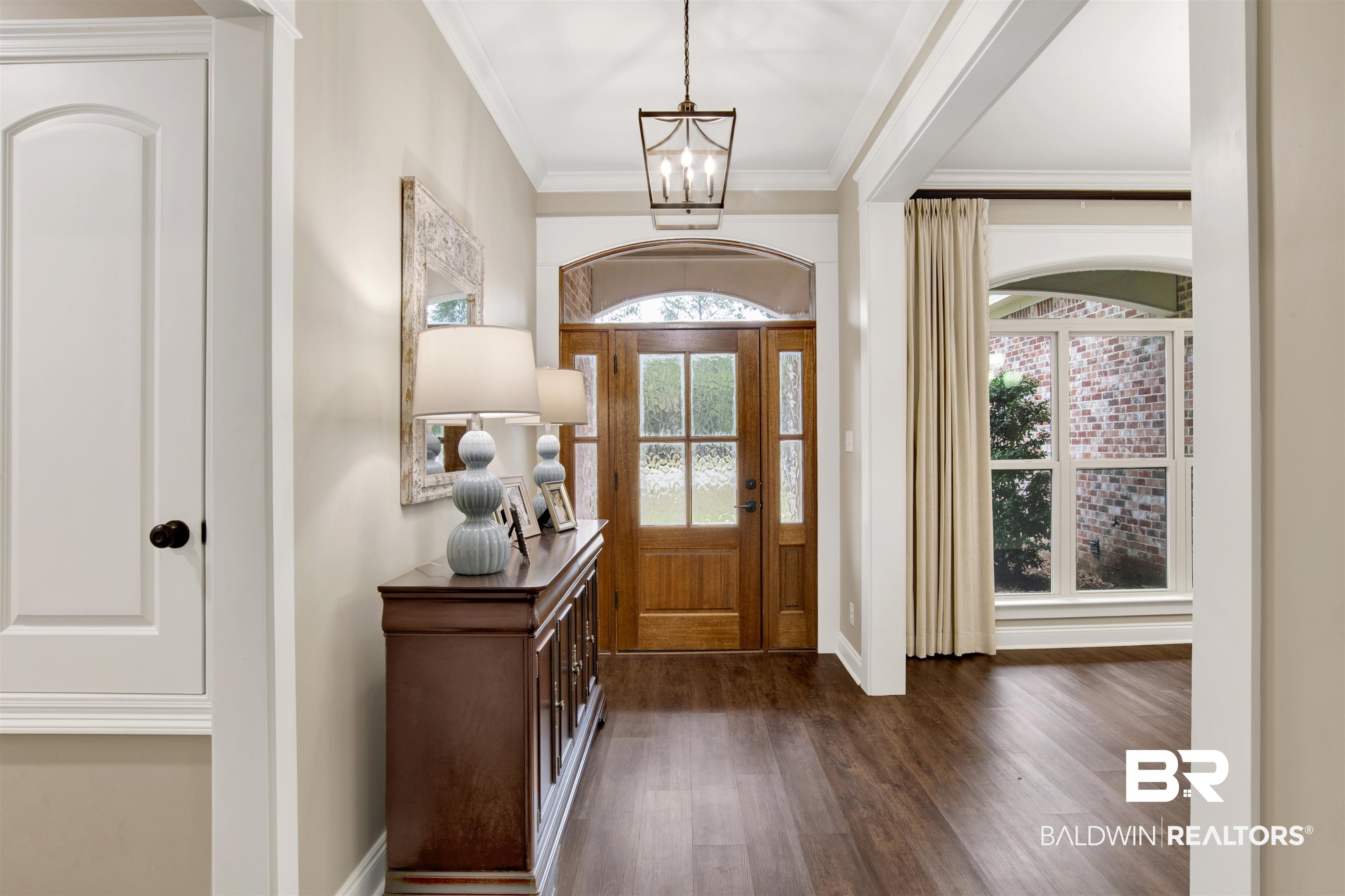 2440 Johnson Road West Mobile, AL 36695 - Photo 10 of 40 Entrance foyer with dark hardwood / wood-style flooring, ornamental molding, and a notable chandelier