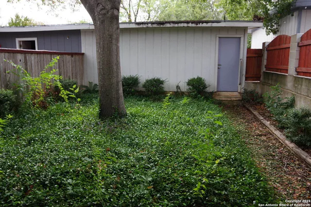 a backyard of a house with plants and outdoor seating