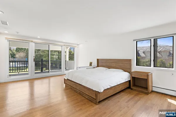 a large white bed sitting in a room next to a window