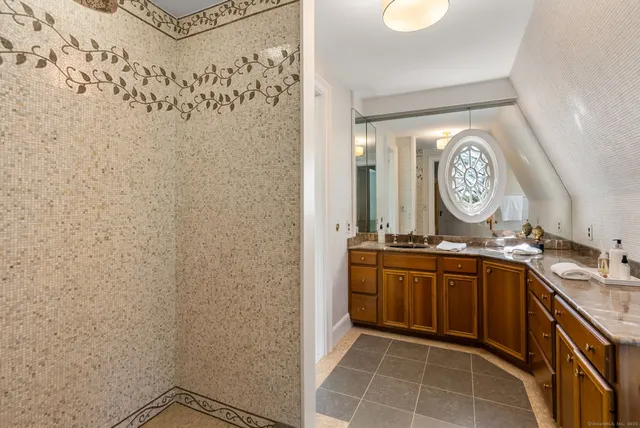 a spacious bathroom with a granite countertop sink a mirror and vanity