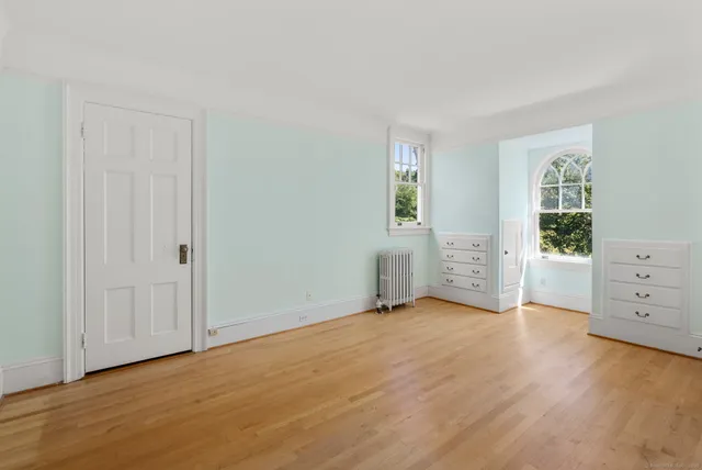 an empty room with furniture and wooden floor