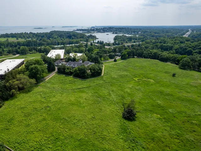 an aerial view of residential houses with outdoor space and trees