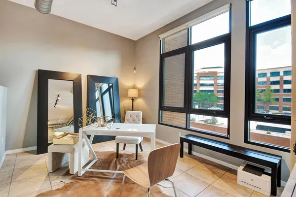 a dining room with furniture and large windows