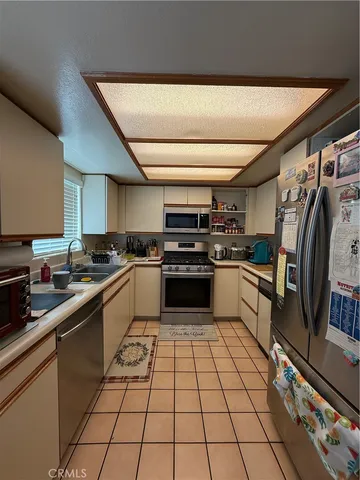 a kitchen with a sink stainless steel appliances and cabinets