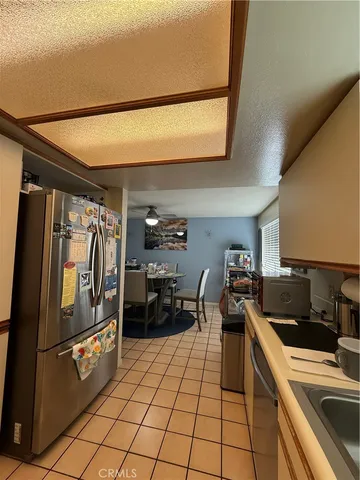a kitchen with granite countertop a refrigerator and a stove top oven