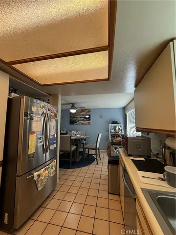 a kitchen with granite countertop a refrigerator and a stove top oven
