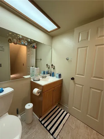 a bathroom with a sink a toilet a mirror and shower
