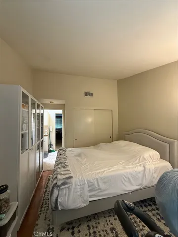 a bedroom with a bed and wooden floor