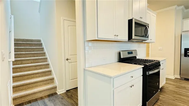 a kitchen with stainless steel appliances granite countertop a stove and a microwave
