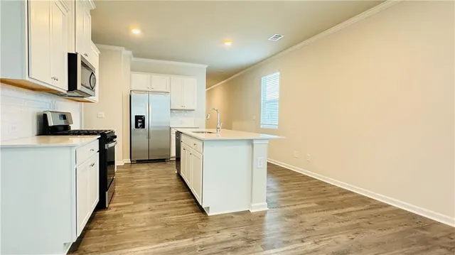a kitchen with stainless steel appliances granite countertop a stove a sink and a refrigerator