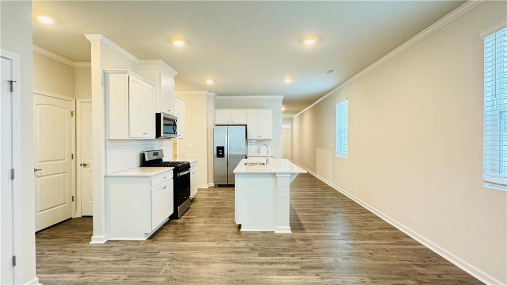 5114 Tulip Square Acworth, GA 30101 - Photo 10 of 36 a large kitchen with a stove a sink dishwasher a refrigerator and white cabinets with wooden floor