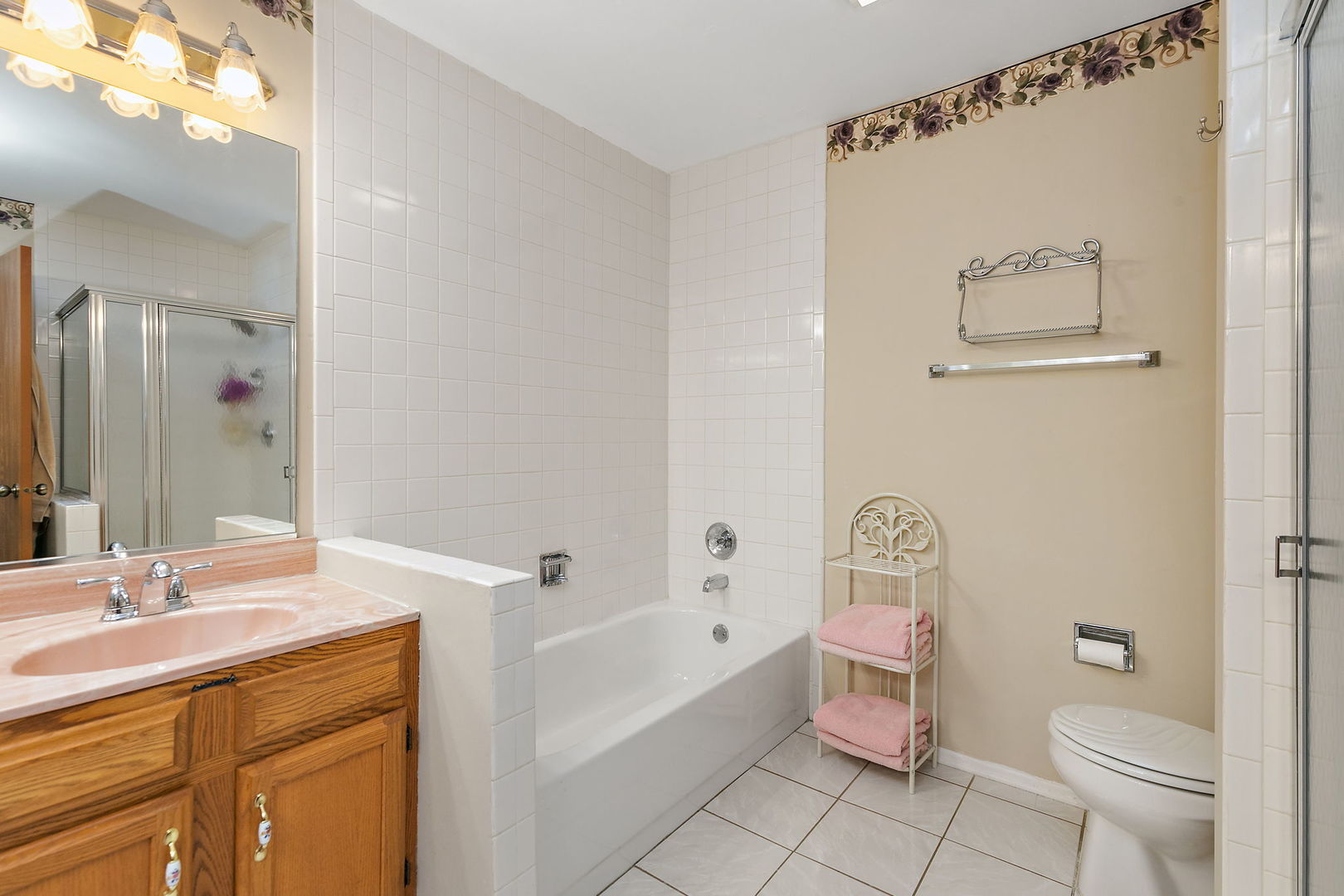 133 White Branch Court South, Unit 133 Schaumburg, IL 60107 - Photo 19 of 27 a bathroom with a sink a mirror a toilet and bathtub
