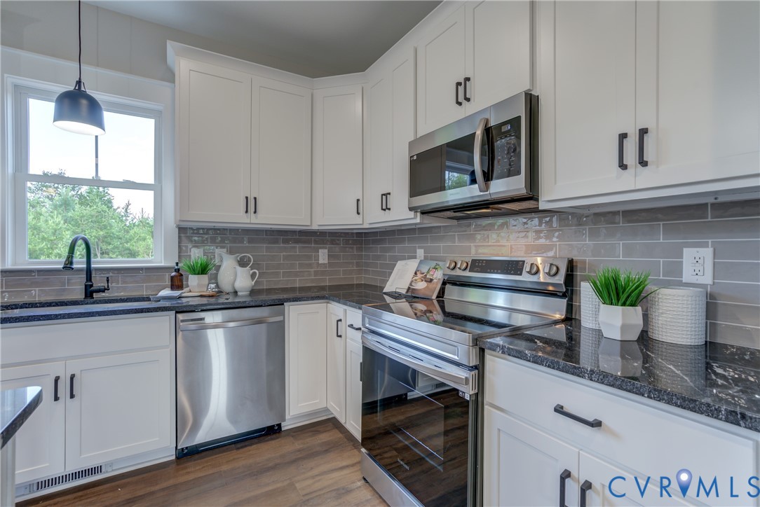 5306 St Pauls Church Road Goochland, VA 23063 - Photo 18 of 35 a kitchen with stainless steel appliances white cabinets a stove a sink and a microwave