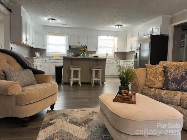 a living room with furniture and kitchen view