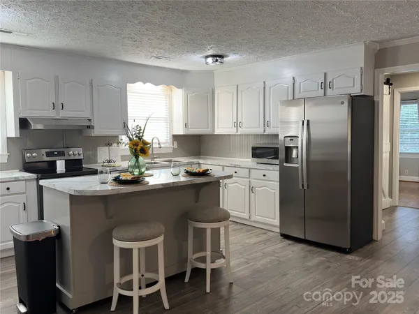 a kitchen with a sink a counter space appliances and cabinets