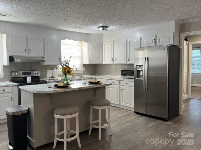 a kitchen with a sink a counter space appliances and cabinets