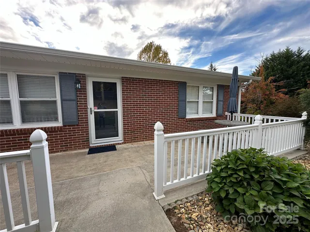 a view of a house with a small yard and wooden floor and fence