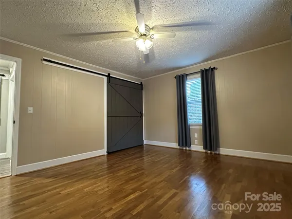 a view of an empty room with wooden floor