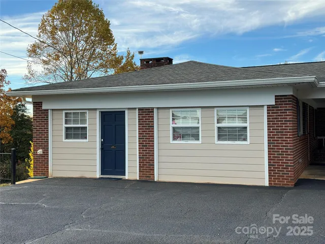 a view of a house with a large window and a yard