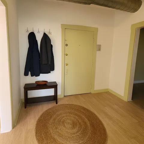 a view of a room with a bed and wooden floor