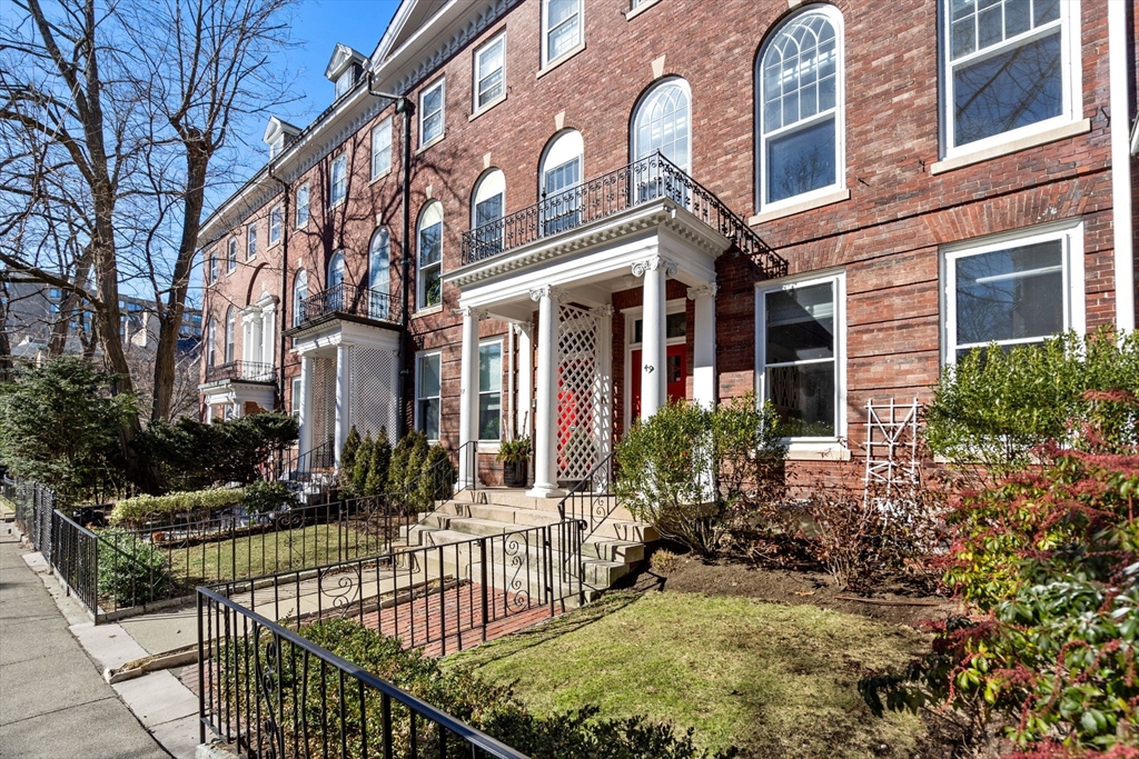 a view of a house with large windows and flower plants