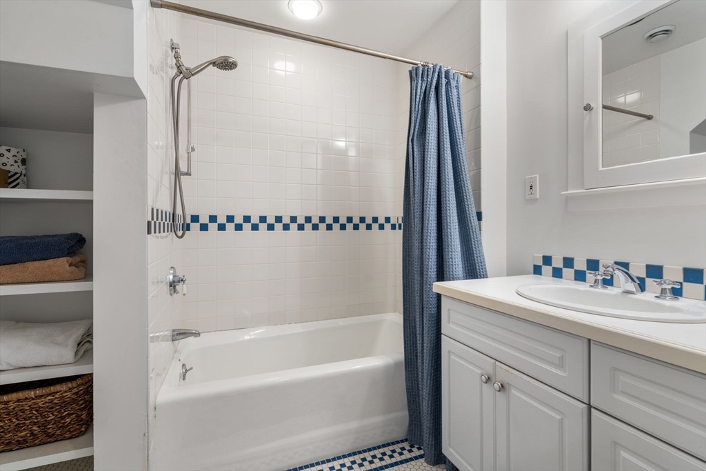 49 Garrison Road Brookline, MA 02445 - Photo 18 of 25 a bathroom with a bathtub shower sink vanity and a toilet