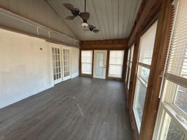 a view of empty room with wooden floor