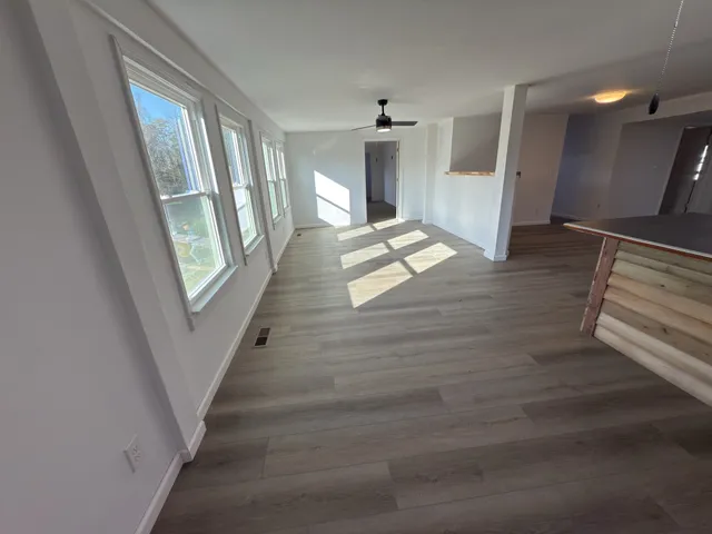 a view of an empty room with wooden floor