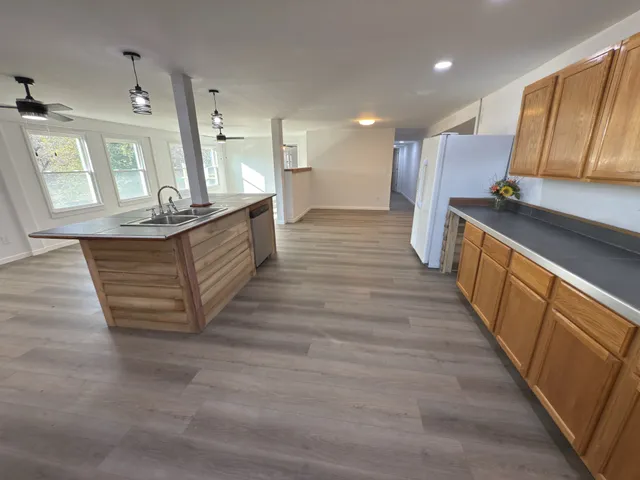 a view of empty room with wooden floor and ceiling fan