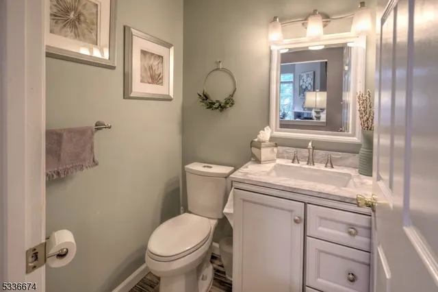 a bathroom with a granite countertop toilet sink and mirror