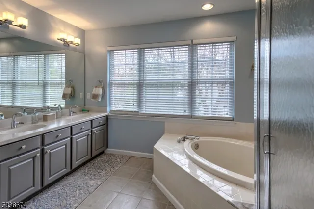 a bathroom with a granite countertop bathtub and a sink