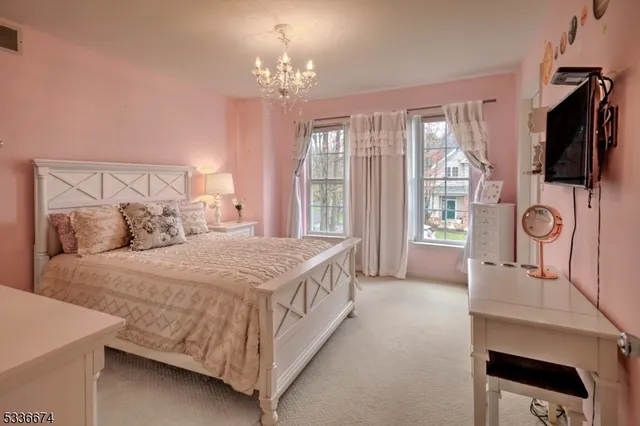 a bedroom with a large bed and a flat tv screen on a dresser