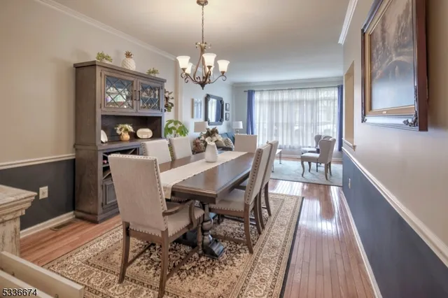 a view of a dining room with furniture a chandelier and wooden floor