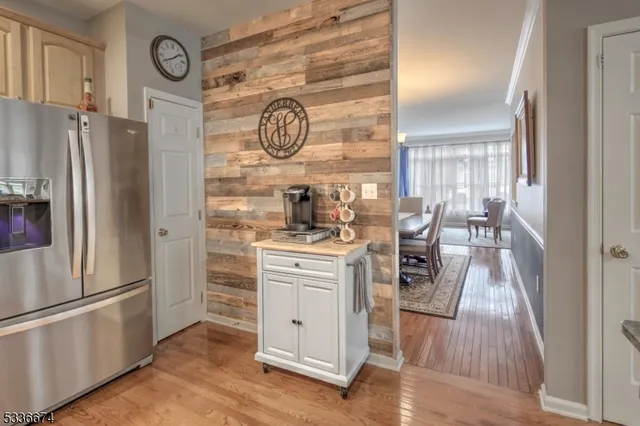 a kitchen with a refrigerator and a clock on wall