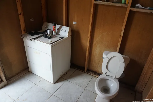 a bathroom with a toilet mirror and vanity