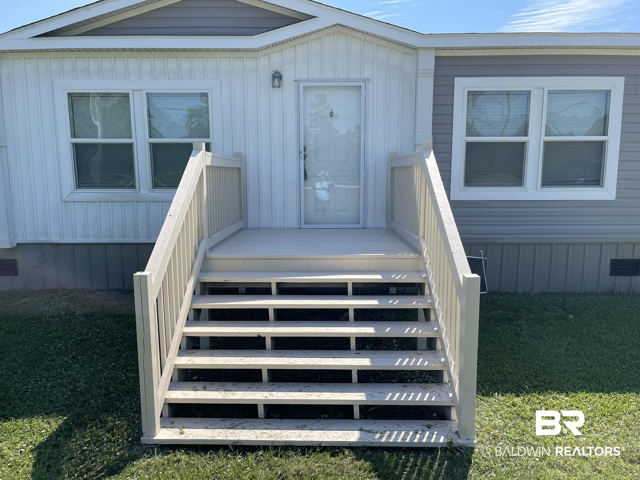 Entrance to property with a yard and a deck