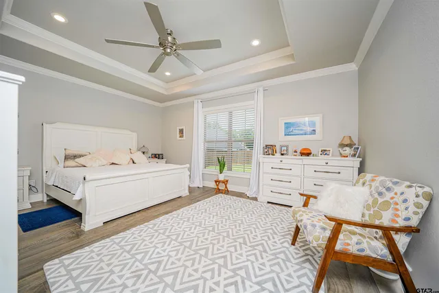 a white bed sitting in a bedroom next to a window with a rug and a table
