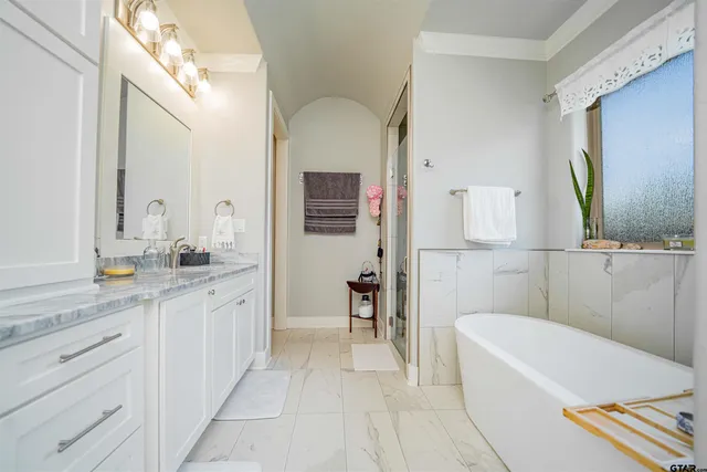a bathroom with a tub sink and mirror